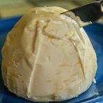 A knife slicing a pat of butter.